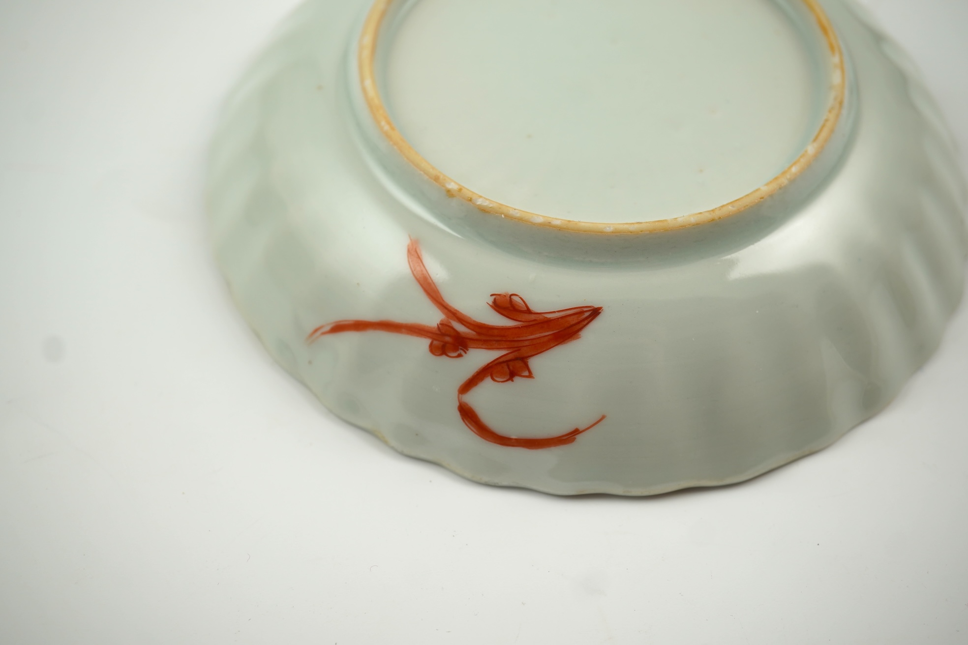 A Chinese rouge de fer tea bowl and saucer and a similar cup, Qianlong period